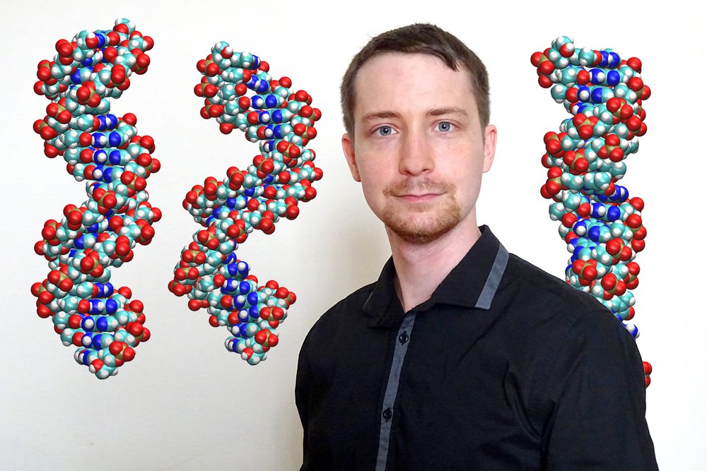 Portrait Johannes Kalliauer, im Hintergrund drei große bunte DNA-Stränge