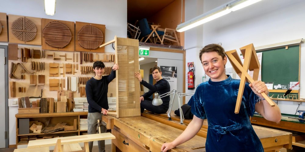 Three students with furnitures in the TU Graz furniture workshop